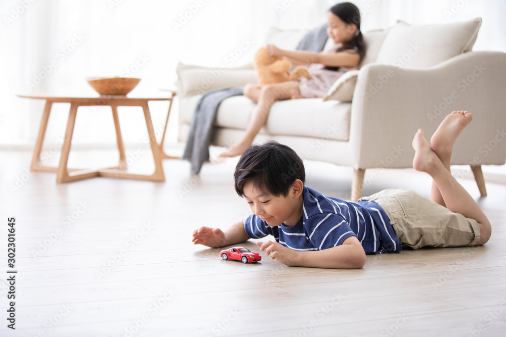 Happy Chinese sibling playing with toys in living room Happy Chinese sibling playing with toys in living room