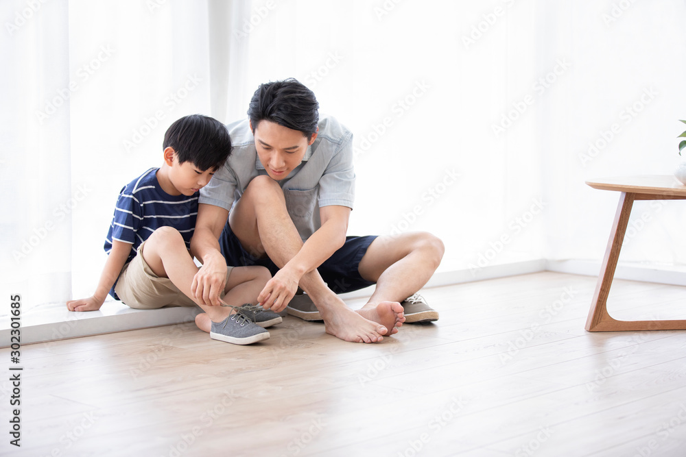 Chinese father teaching his son to tie shoelaces Chinese father teaching his son to tie shoelaces