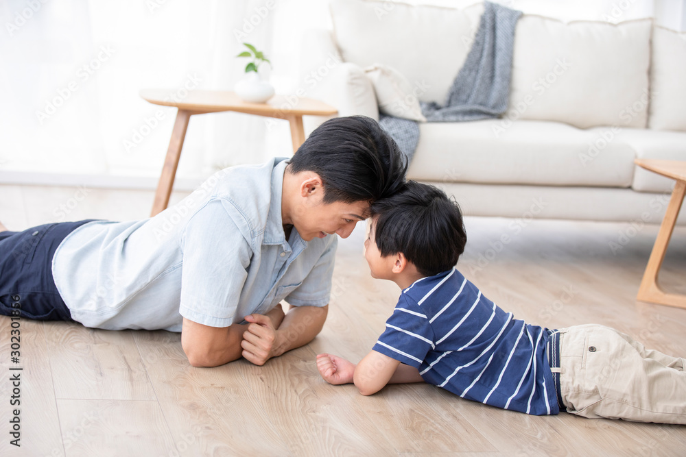 Chinese father and son lying on floor Chinese father and son lying on floor