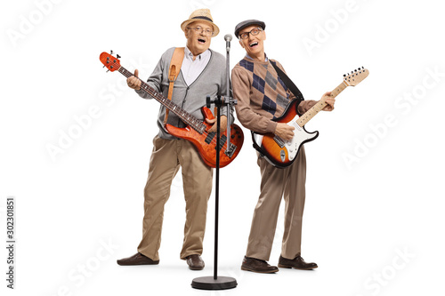 Two elderly gentlemen playing guitars and singing on a microphone © Ljupco Smokovski