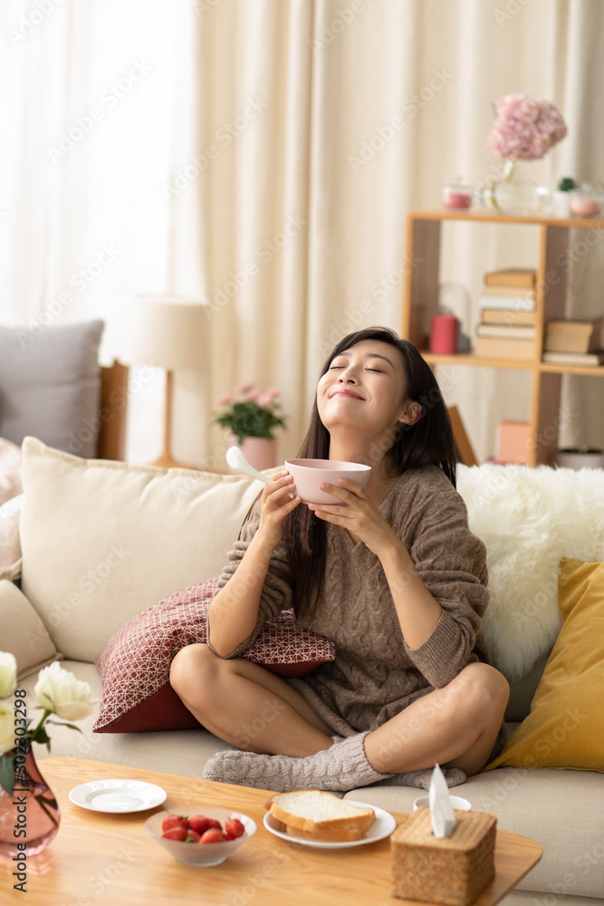 Young Chinese woman having breakfast at home Young Chinese woman having breakfast at home