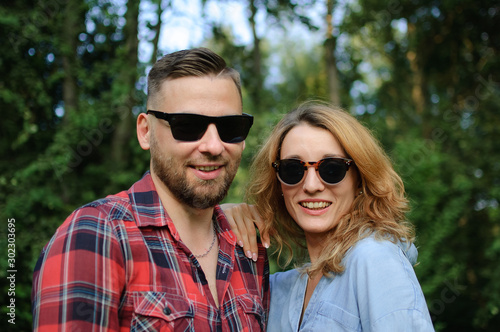 Young couple in sunglasses spending time together and walking in the spring park © Ольга 