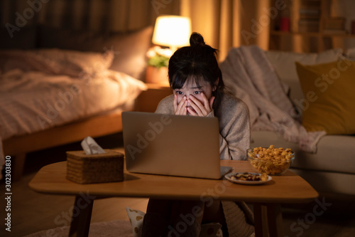 Young Chinese woman watching movie on laptop photo