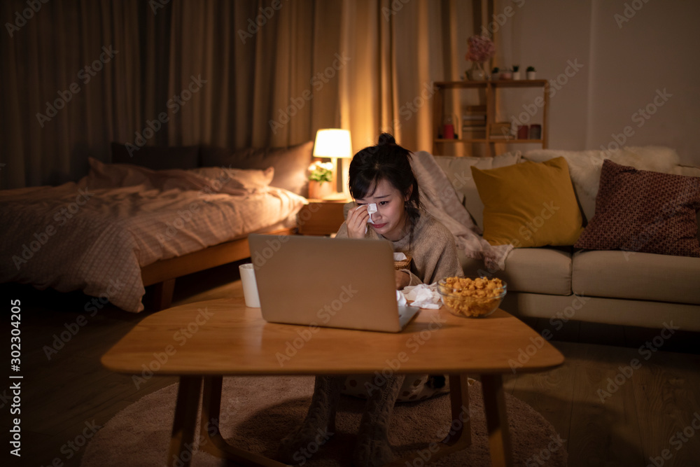 © Blue Jean Images - Young Chinese woman watching movie on laptop © Blue Jean Images - Young Chinese woman watching movie on laptop