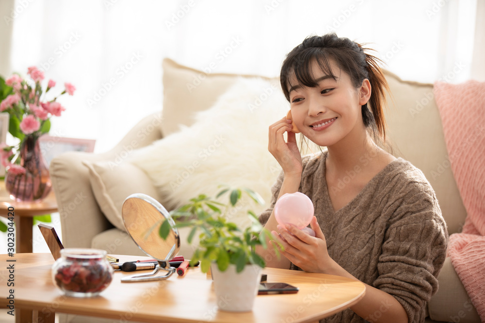 Young Chinese woman applying makeup at home Young Chinese woman applying makeup at home