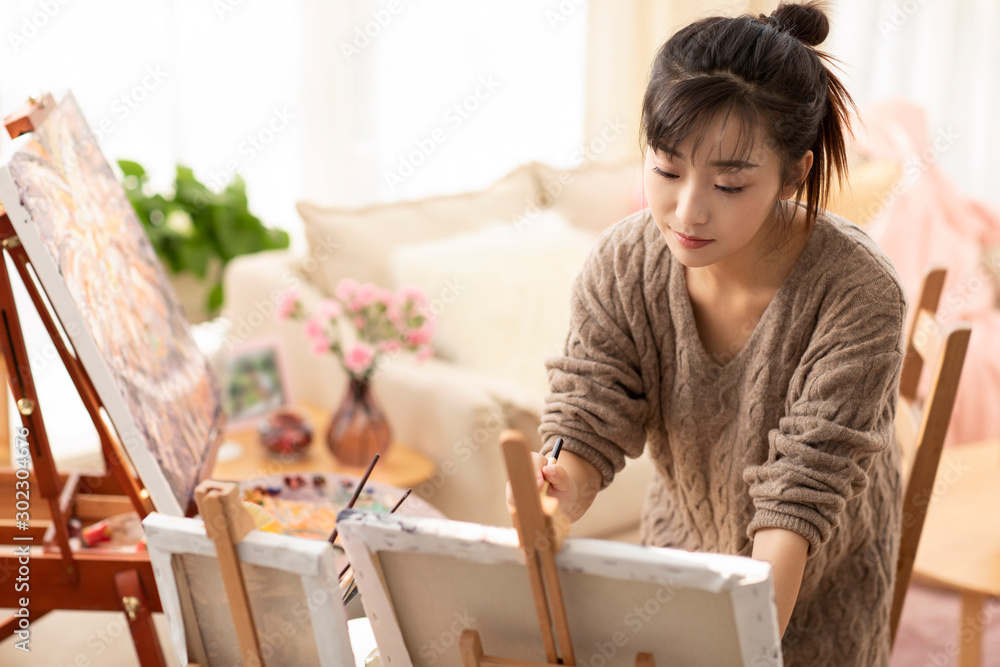 Young Chinese woman painting at home Young Chinese woman painting at home