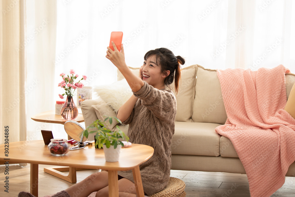 Young Chinese woman doing live webcast at home Young Chinese woman doing live webcast at home