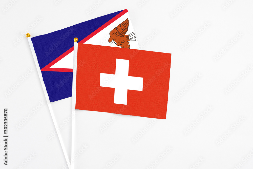 Switzerland and American Samoa stick flags on white background. High quality fabric, miniature national flag. Peaceful global concept.White floor for copy space.
