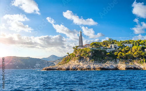View from the Mediterranean Sea of the Saint Jean Cap Ferrat lighthouse as the sun begins to set on the French Riviera in the South of France. photo