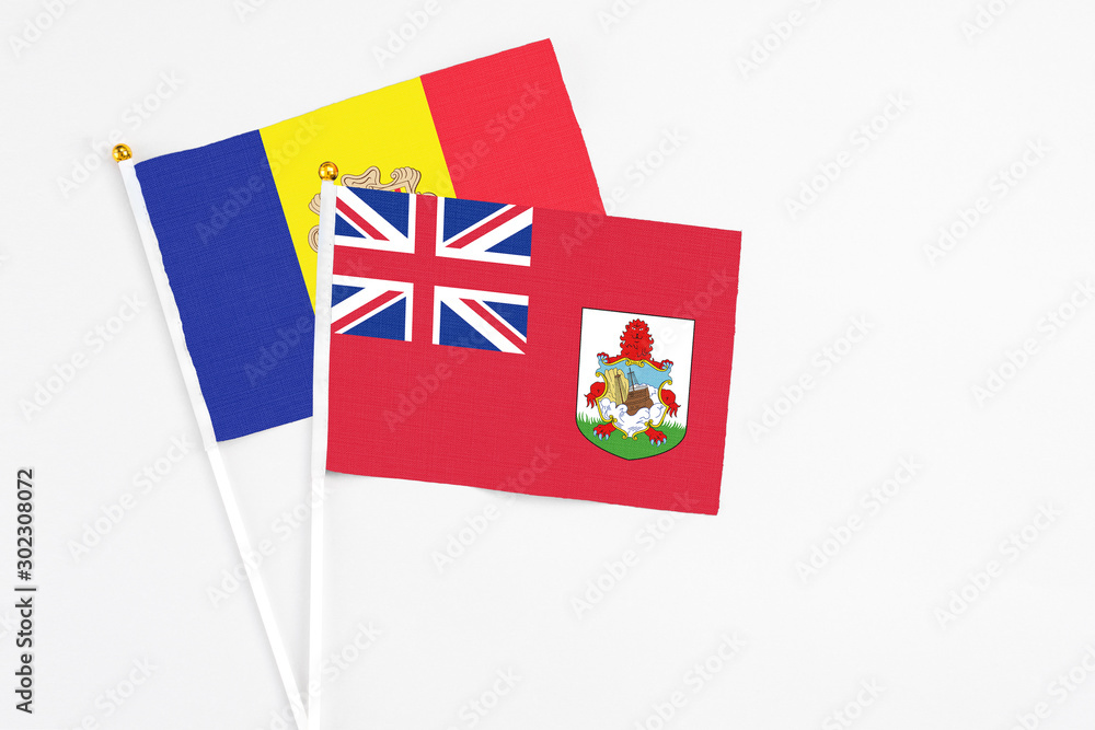 Fototapeta premium Bermuda and Andorra stick flags on white background. High quality fabric, miniature national flag. Peaceful global concept.White floor for copy space.