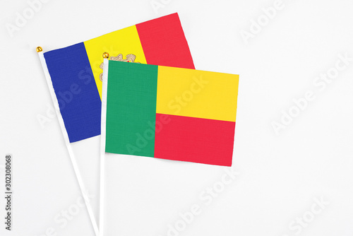 Benin and Andorra stick flags on white background. High quality fabric  miniature national flag. Peaceful global concept.White floor for copy space.