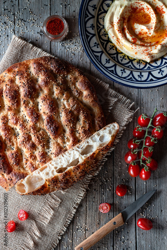 From above loaf of Ramazan pidesi placed near fresh tomatoes and spices on lumber tabletop photo