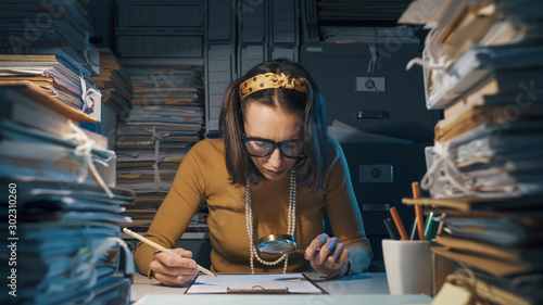 Businesswoman checking a contract with a magnifier photo