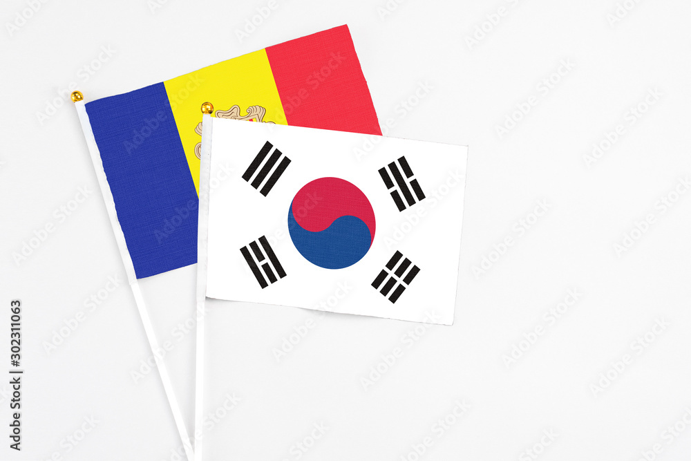 South Korea and Andorra stick flags on white background. High quality fabric, miniature national flag. Peaceful global concept.White floor for copy space.