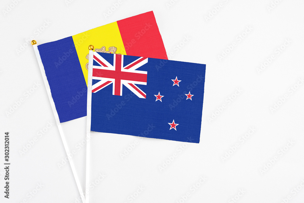 Fototapeta premium New Zealand and Andorra stick flags on white background. High quality fabric, miniature national flag. Peaceful global concept.White floor for copy space.