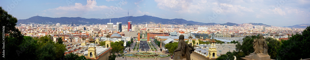 Panoramic of Barcelona with the towers in the Plaza Espana, the bullring, the ancient sculptures and the mountains in the background