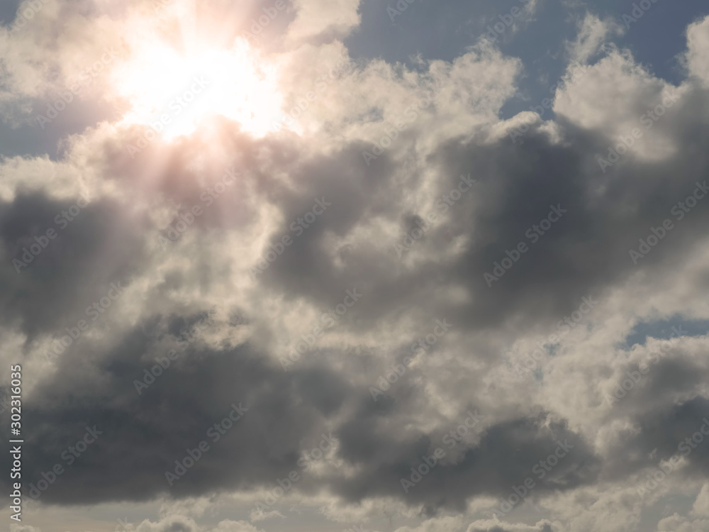 Abstract nature background, Cloudy sky, Sun shines through, flare and rays of light.