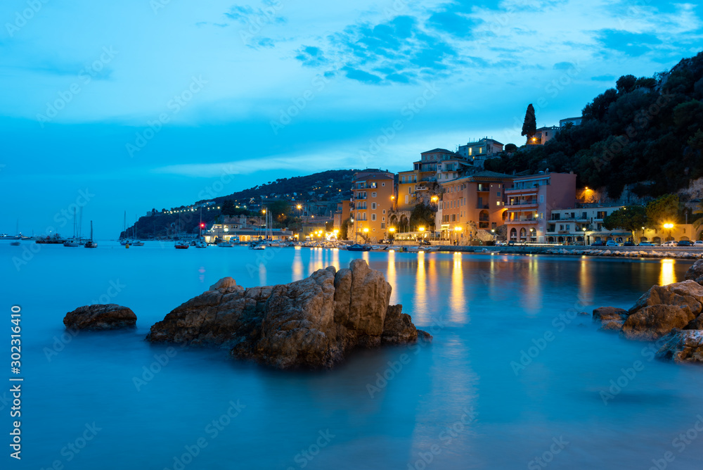 Villefranche-sur-Mer during sunset, French Riviera, Cote d'Azur, France. Long exposure, lights reflecting in the sea. 
