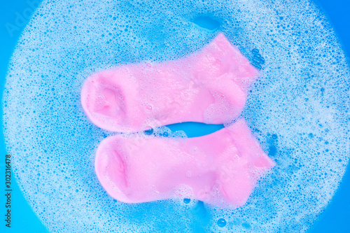 Pink  socks soaking in powder detergent water dissolution. Laund photo