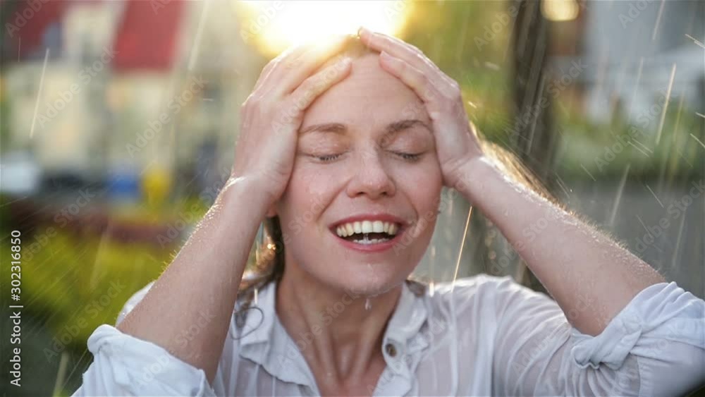 Happy Young Smiling Woman Having Fun In Rainy Weather. Cheerful Lady Has Wet Hair In Summer Park. Happy Young Smiling Woman Having Fun In Rainy Weather. Cheerful Lady Has Wet Hair In Summer Park.