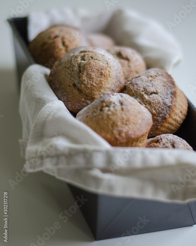 Fresh homemade muffins in form for cooking on white background.