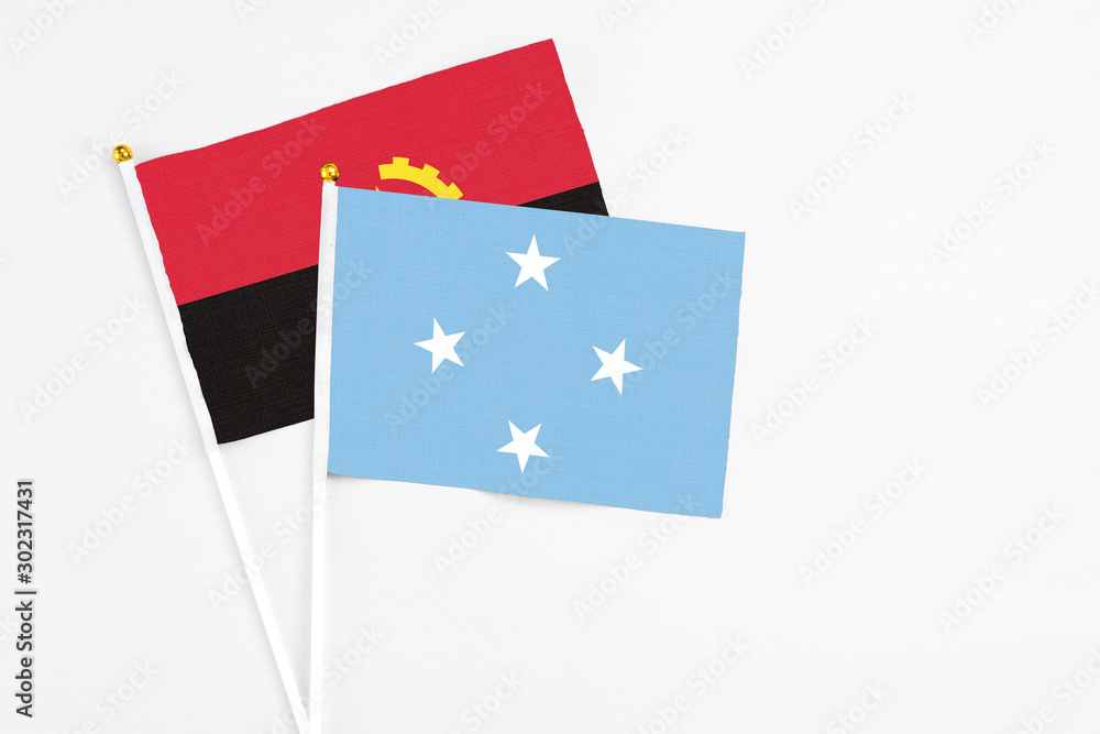 Micronesia and Angola stick flags on white background. High quality fabric, miniature national flag. Peaceful global concept.White floor for copy space. Micronesia and Angola stick flags on white background. High quality fabric, miniature national flag. Peaceful global concept.White floor for copy space.
