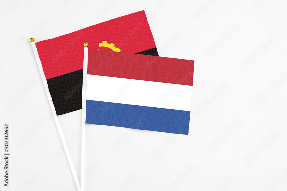 Netherlands and Angola stick flags on white background. High quality fabric, miniature national flag. Peaceful global concept.White floor for copy space. Netherlands and Angola stick flags on white background. High quality fabric, miniature national flag. Peaceful global concept.White floor for copy space.