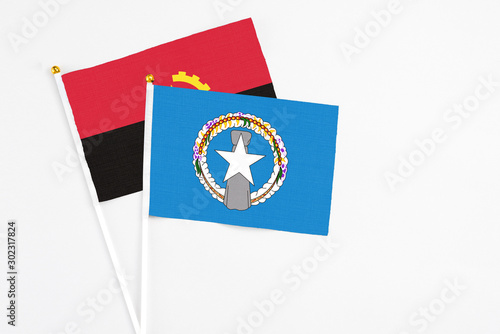Free Download Northern Mariana Islands and Angola stick flags on white background. High quality fabric, miniature national flag. Peaceful global concept.White floor for copy space. - GFXLoad