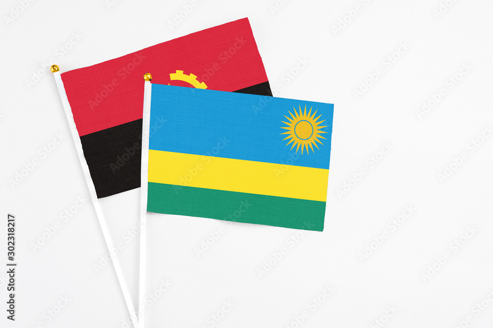 Rwanda and Angola stick flags on white background. High quality fabric, miniature national flag. Peaceful global concept.White floor for copy space. Rwanda and Angola stick flags on white background. High quality fabric, miniature national flag. Peaceful global concept.White floor for copy space.