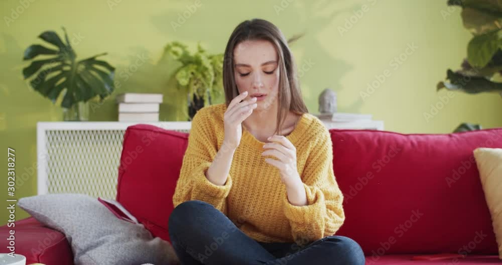 Frustrated young woman in distress using two phones throwing them on couch. Busy upset millennial girl sitting on sofa in the house. Frustrated young woman in distress using two phones throwing them on couch. Busy upset millennial girl sitting on sofa in the house.