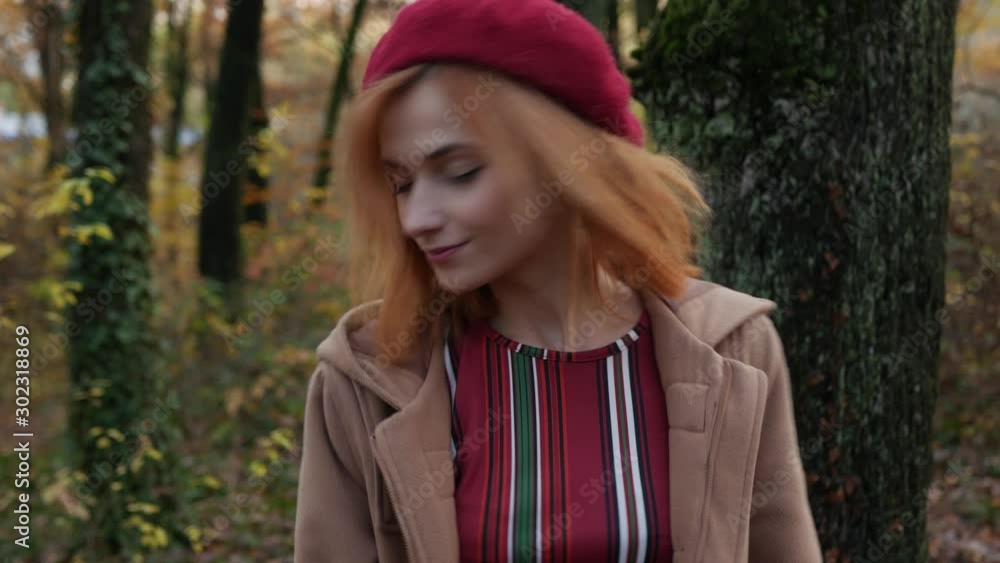 Girl shows emotions of joy in the forest in a red beret Girl shows emotions of joy in the forest in a red beret