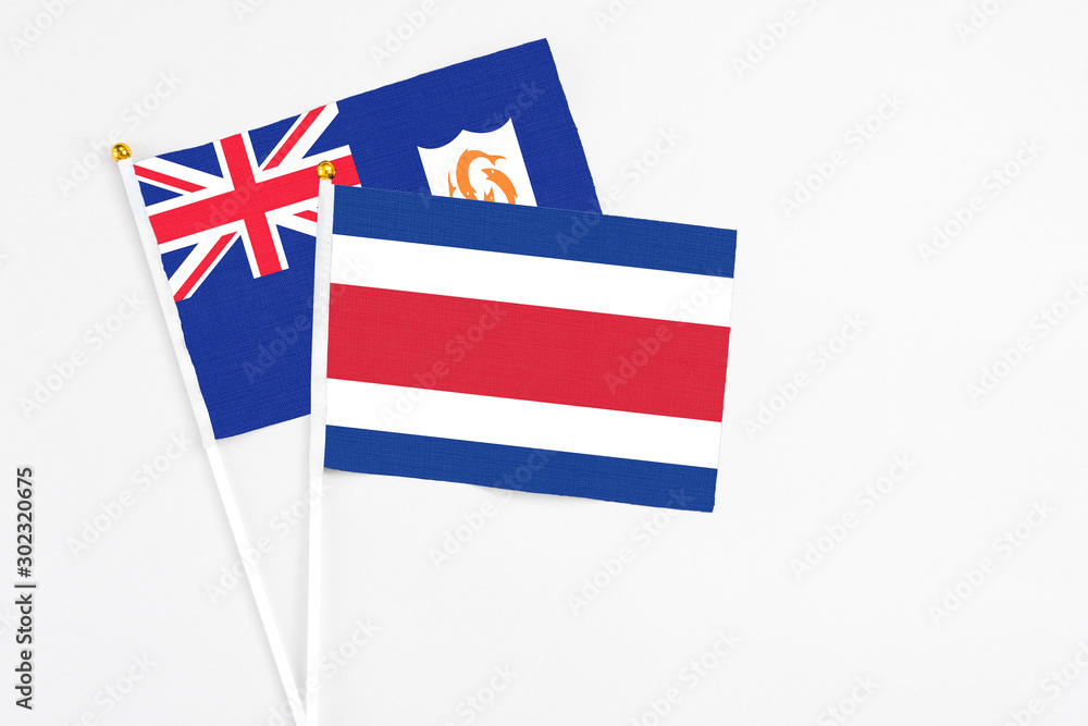 Costa Rica and Anguilla stick flags on white background. High quality fabric, miniature national flag. Peaceful global concept.White floor for copy space. Costa Rica and Anguilla stick flags on white background. High quality fabric, miniature national flag. Peaceful global concept.White floor for copy space.