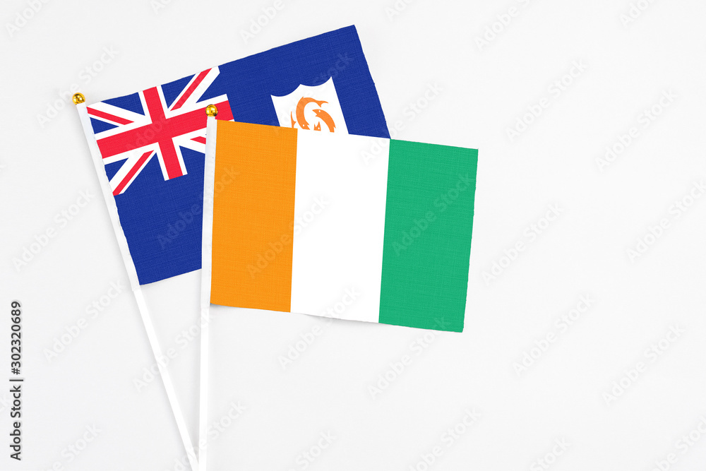 Cote D'Ivoire and Anguilla stick flags on white background. High quality fabric, miniature national flag. Peaceful global concept.White floor for copy space. Cote D'Ivoire and Anguilla stick flags on white background. High quality fabric, miniature national flag. Peaceful global concept.White floor for copy space.