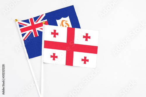 Georgia and Anguilla stick flags on white background. High quality fabric, miniature national flag. Peaceful global concept.White floor for copy space.