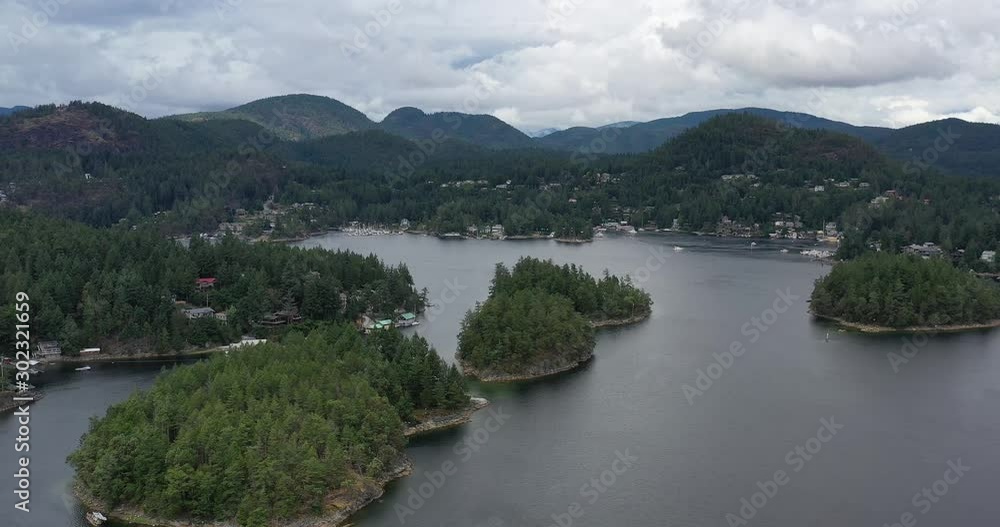 View over inlet, ocean and island with boat and mountains in beautiful British Columbia. Canada. Aerial drone flying. 4K. View over inlet, ocean and island with boat and mountains in beautiful British Columbia. Canada. Aerial drone flying. 4K.