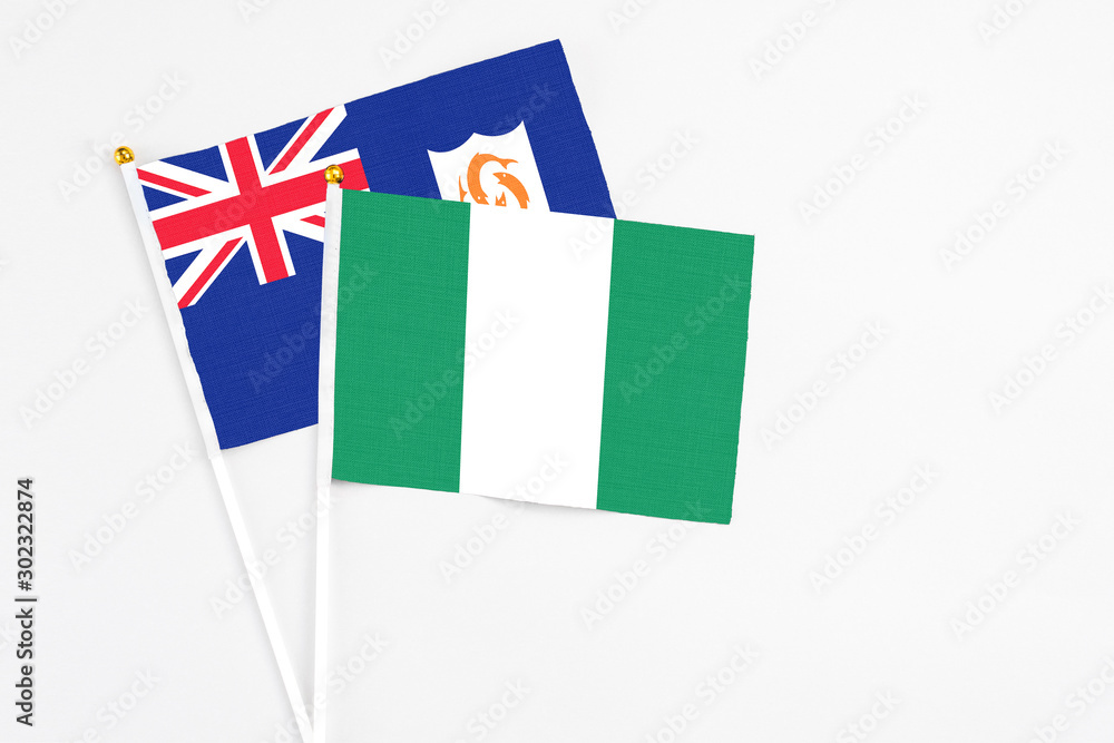 Nigeria and Anguilla stick flags on white background. High quality fabric, miniature national flag. Peaceful global concept.White floor for copy space. Nigeria and Anguilla stick flags on white background. High quality fabric, miniature national flag. Peaceful global concept.White floor for copy space.