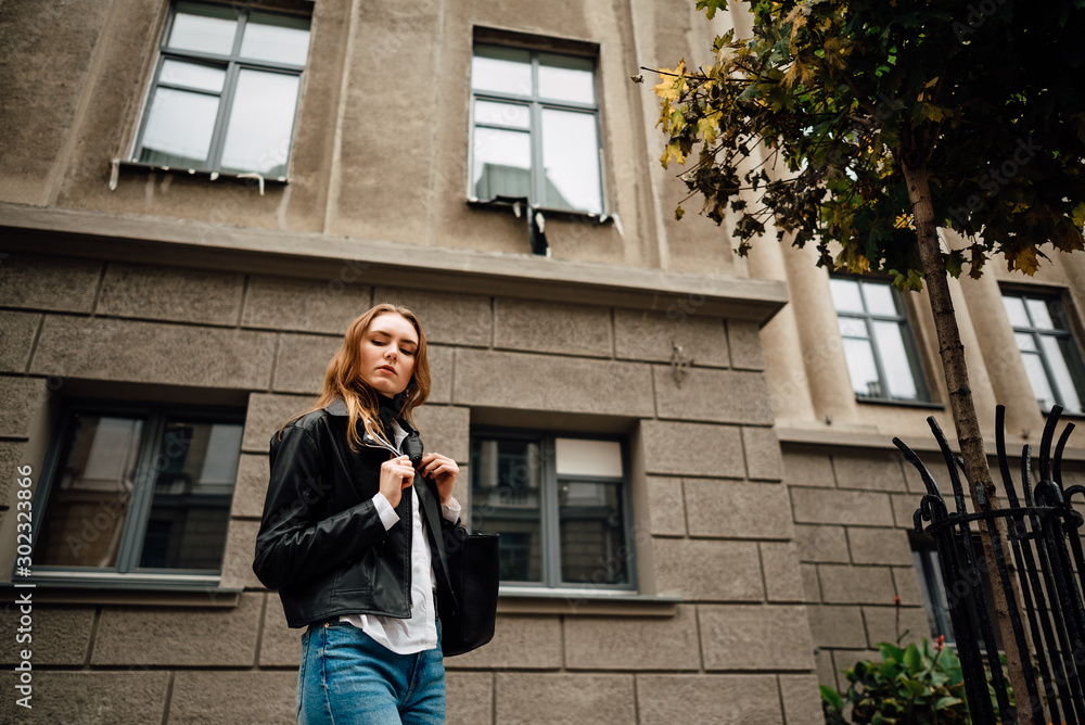 beautiful young girl in leather jacket and jeans resting outdoors, portrait of woman in the city beautiful young girl in leather jacket and jeans resting outdoors, portrait of woman in the city