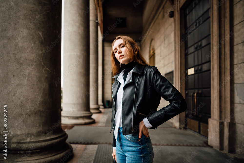 young lovely girl in leather jacket and jeans resting outdoors, portrait of woman with beautiful hair in the city young lovely girl in leather jacket and jeans resting outdoors, portrait of woman with beautiful hair in the city