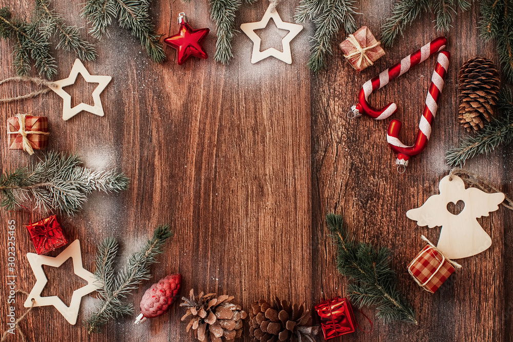 Fototapeta premium Christmas decorations and fir branches on brown wooden background