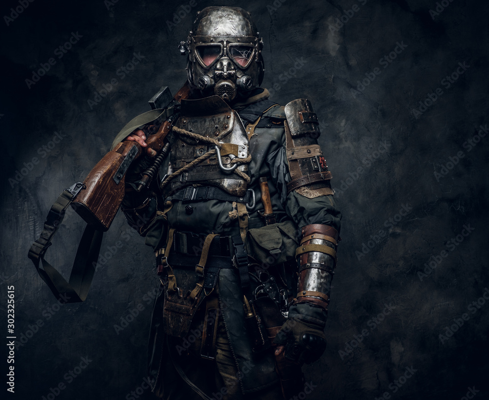 Portrait of a man in interesting costume of dark apocalypse warrior at photo studio.
