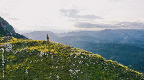 Successful hiker outstretched arms at seaside mountain top cliff edge