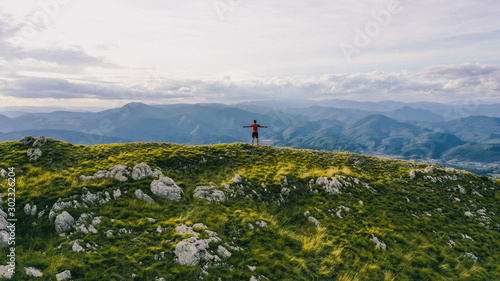 Successful hiker outstretched arms at seaside mountain top cliff edge