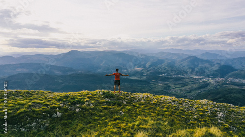 Successful hiker outstretched arms at seaside mountain top cliff edge