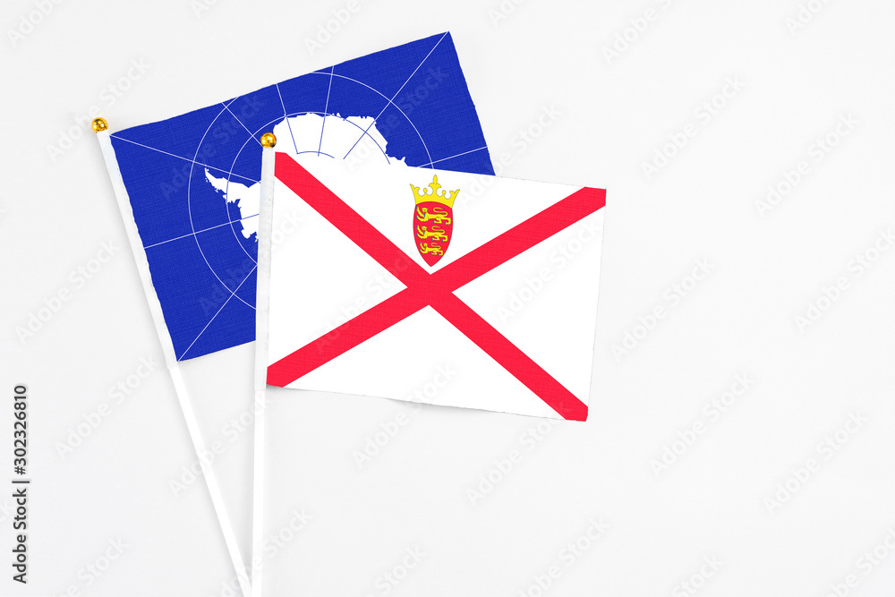 Jersey and Antarctica stick flags on white background. High quality fabric, miniature national flag. Peaceful global concept.White floor for copy space. Jersey and Antarctica stick flags on white background. High quality fabric, miniature national flag. Peaceful global concept.White floor for copy space.
