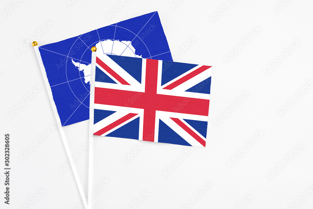 United Kingdom and Antarctica stick flags on white background. High quality fabric, miniature national flag. Peaceful global concept.White floor for copy space. United Kingdom and Antarctica stick flags on white background. High quality fabric, miniature national flag. Peaceful global concept.White floor for copy space.