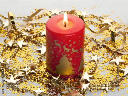 Fotografie Christmas composition of the red Christmas candle and gold stars
