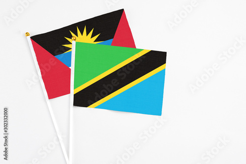 Tanzania and Antigua and Barbuda stick flags on white background. High quality fabric, miniature national flag. Peaceful global concept.White floor for copy space. photo