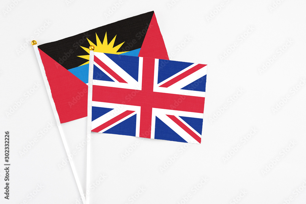 United Kingdom and Antigua and Barbuda stick flags on white background. High quality fabric, miniature national flag. Peaceful global concept.White floor for copy space. United Kingdom and Antigua and Barbuda stick flags on white background. High quality fabric, miniature national flag. Peaceful global concept.White floor for copy space.