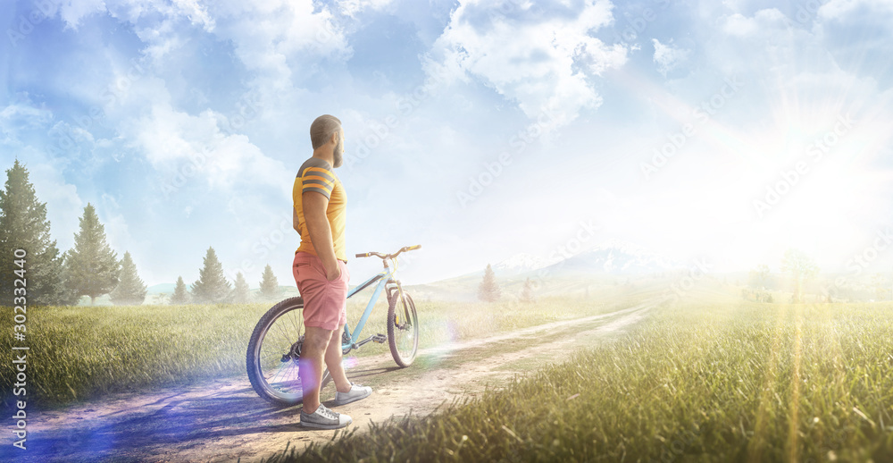 Cycling. Man with bike on a forest road in the mountains on a summer day. Sport