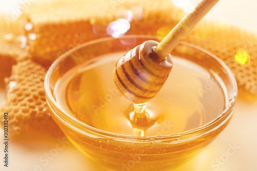 Honey and  wooden spoon  on background